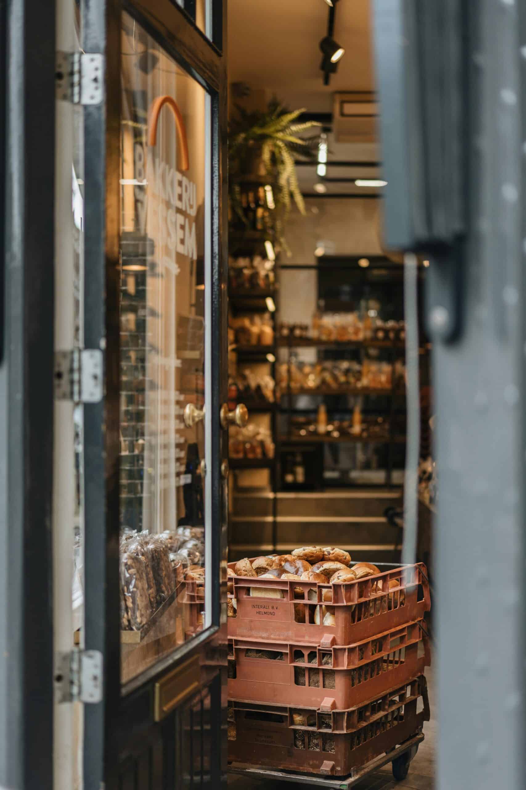 Inviting bakery entrance in Amsterdam with fresh bread crates ready for display.