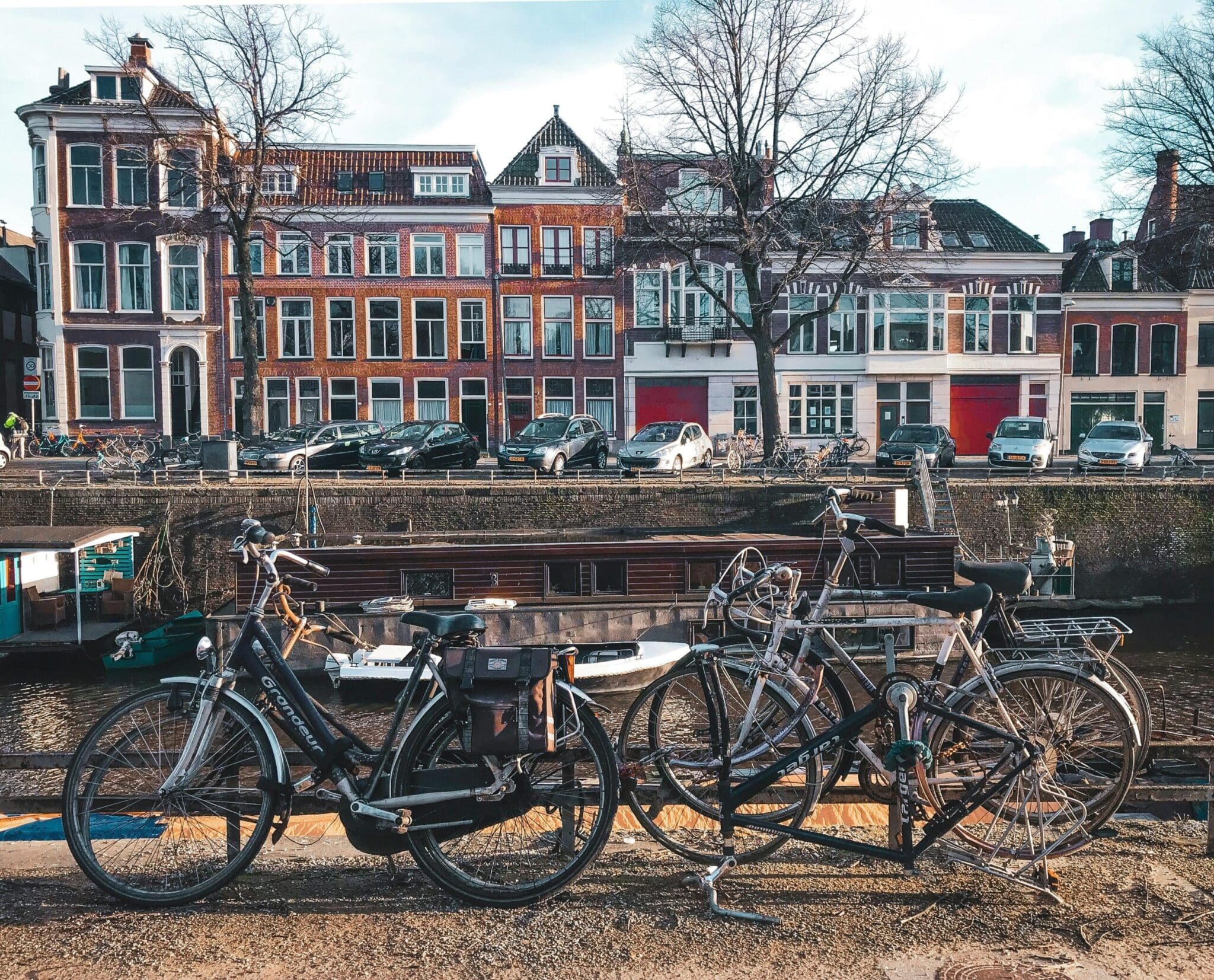 Picturesque street view of Groningen featuring bicycles, canal, and historic architecture on a sunny day.